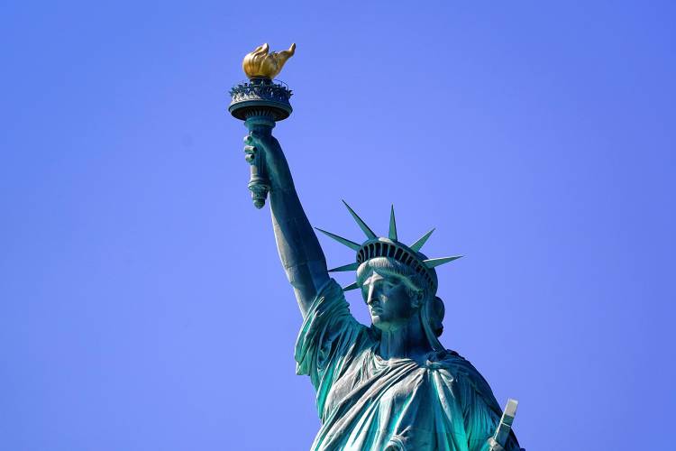 The Statue of Liberty, the presiding symbol of America welcoming refugees, stands in New York Harbor.