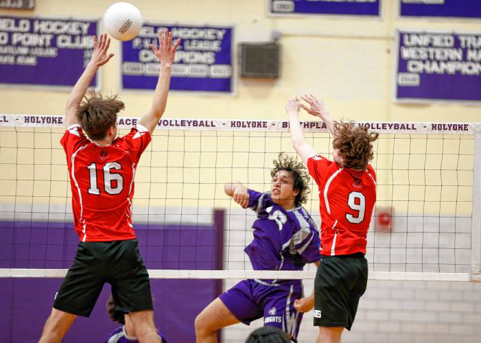 Holyoke’s Michael Melendez (16) gets a kill past Athol blockers Ethan Goodwin (16) and Warren Taylor (9) in the second set Friday in Holyoke.