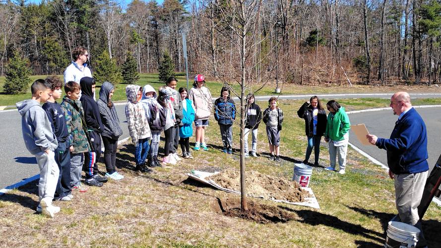 Athol Town Manager Shaun Suhoski (far right) reads a proclamation declaring April 25, 2024 Arbor Day in the Town of Athol. To celebrate the day, fourth-graders from Athol Community Elementary planted a red maple outside the school.
