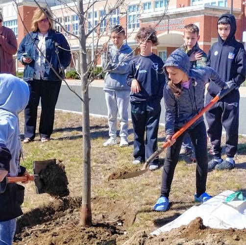 Fourth-graders from the class of teacher Ben Ledgard shovel dirt around the red maple sapling planted at Athol Community Elementary School in honor of Arbor Day.