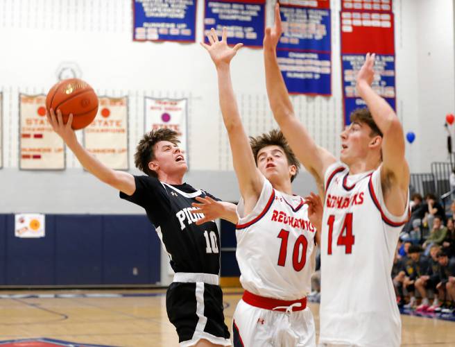 Pioneer’s Brayden Thayer (10) hooks a shot over Frontier defenders Max Millette (10) and Owen Babb (14) in the first quarter Friday night at Goodnow Gymnasium in South Deerfield.