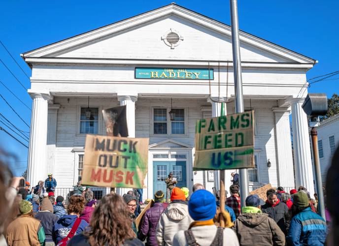 Crowd members listen to Harrison Bardwell, of Bardwell Farm in Hatfield, speak during an “Attack on Small Farms” rally Sunday in front of Hadley Town Hall. Some 300 farmers from throughout the region were protesting proposed cuts and funding freezes involving the U.S. Department of Agriculture.