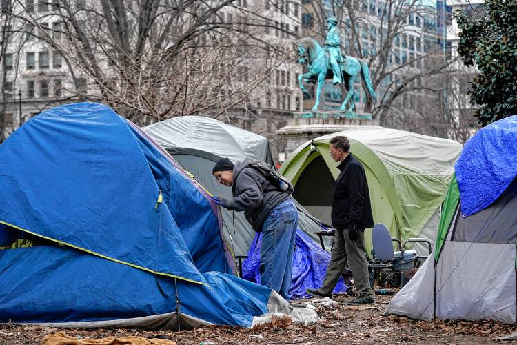 Homeless advocates check inside tents at McPherson Square in Washington, Wednesday, Feb. 15, 2023, prior to a clearing of a homeless encampment by the National Park Service. 